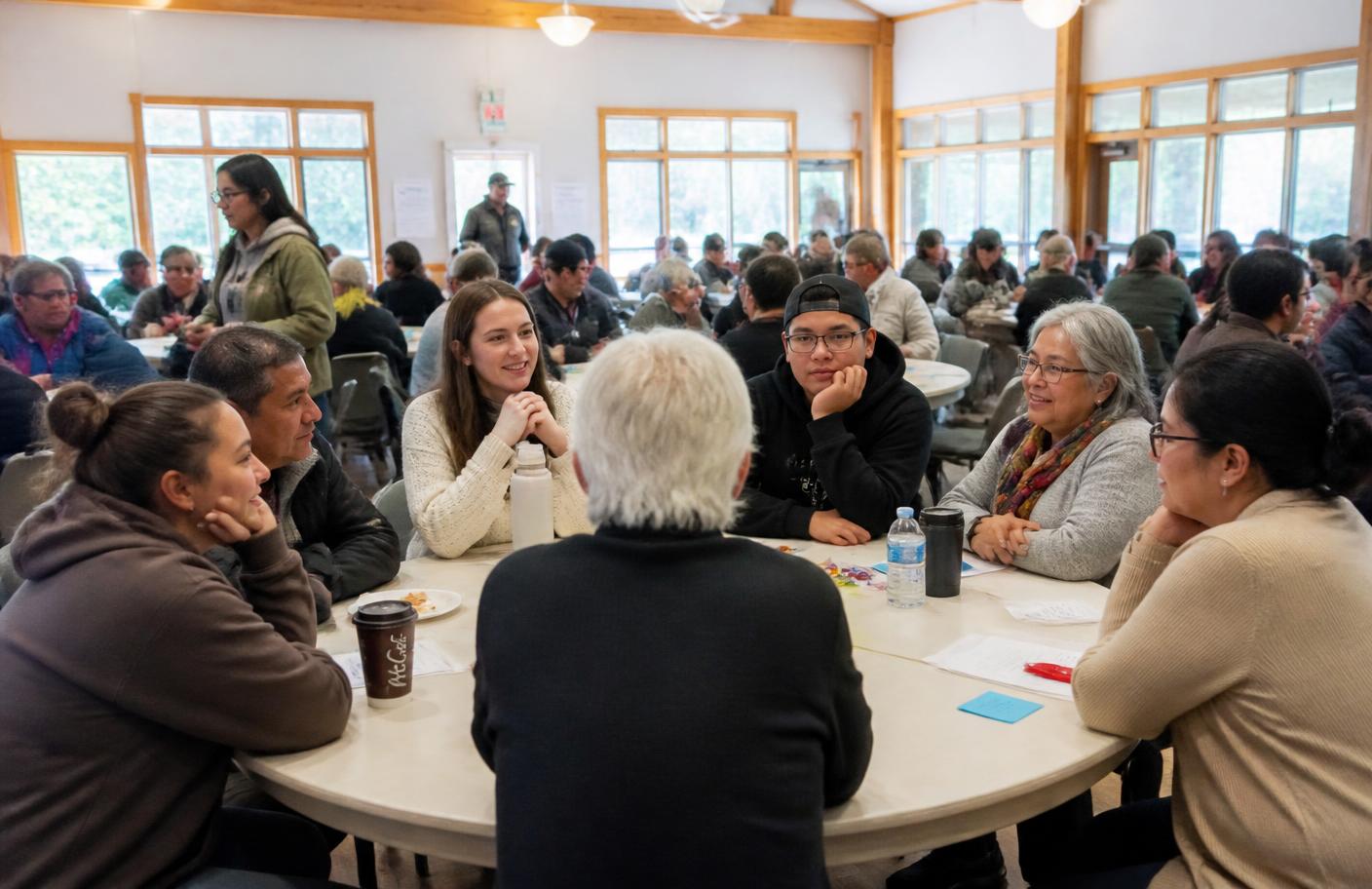People of many ages seated in conversation at a community gathering