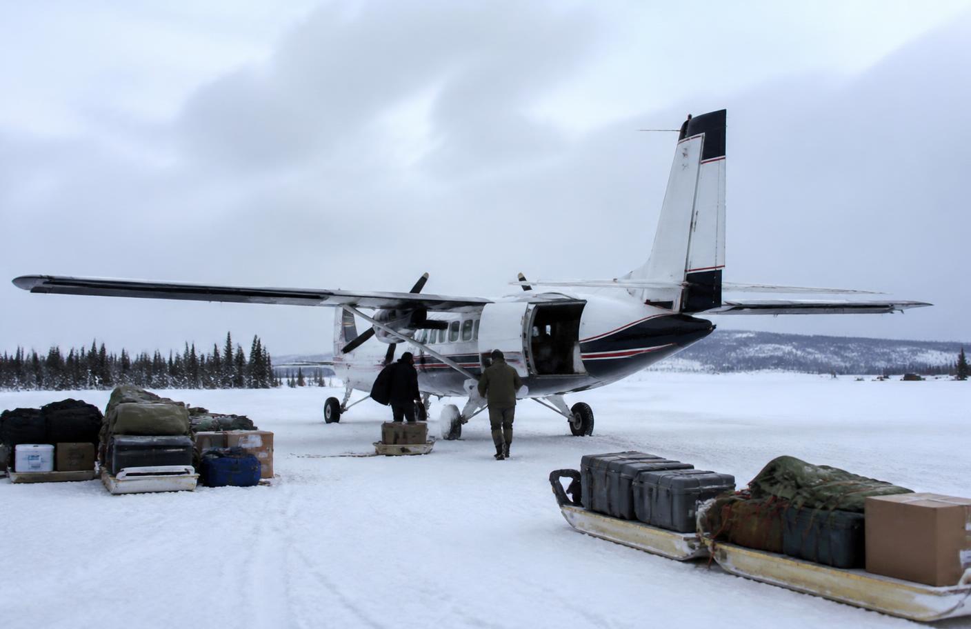 Small aircraft being loaded on a snow-covered northern airstrip